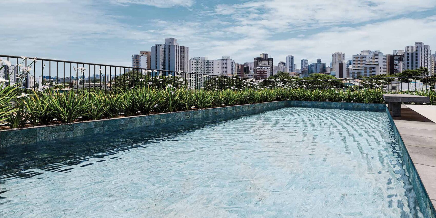 Piscina de borda infinita com o skyline de Pinheiros ao fundo